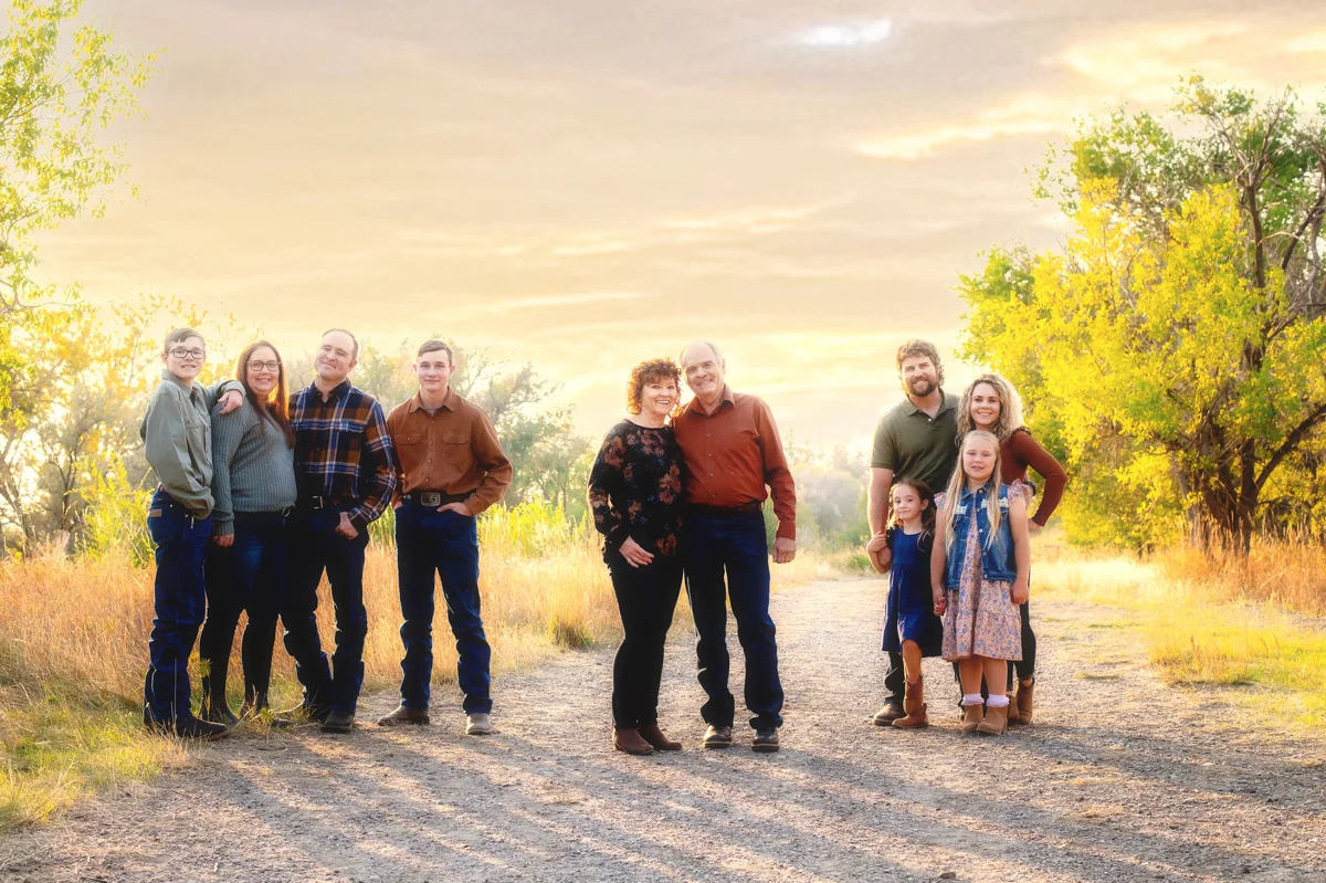 Extended family group standing together at sunset