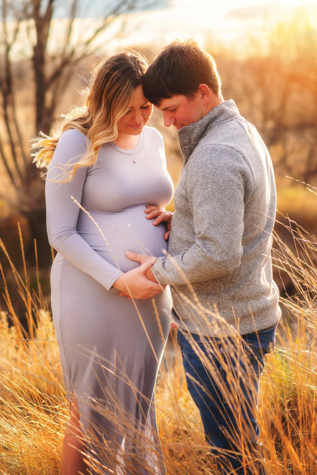Expectant couple embracing in a field
