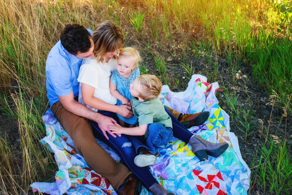 Family relaxing together on a blanket outdoors