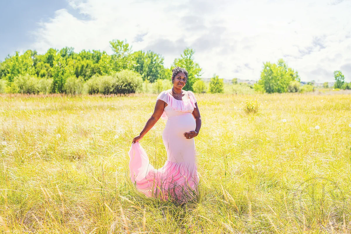Expectant mother in a pink dress outdoors