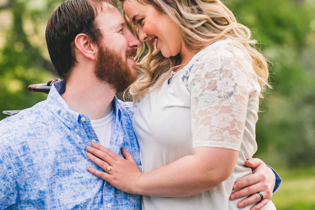 Engaged couple smiling together, with engagement ring visible