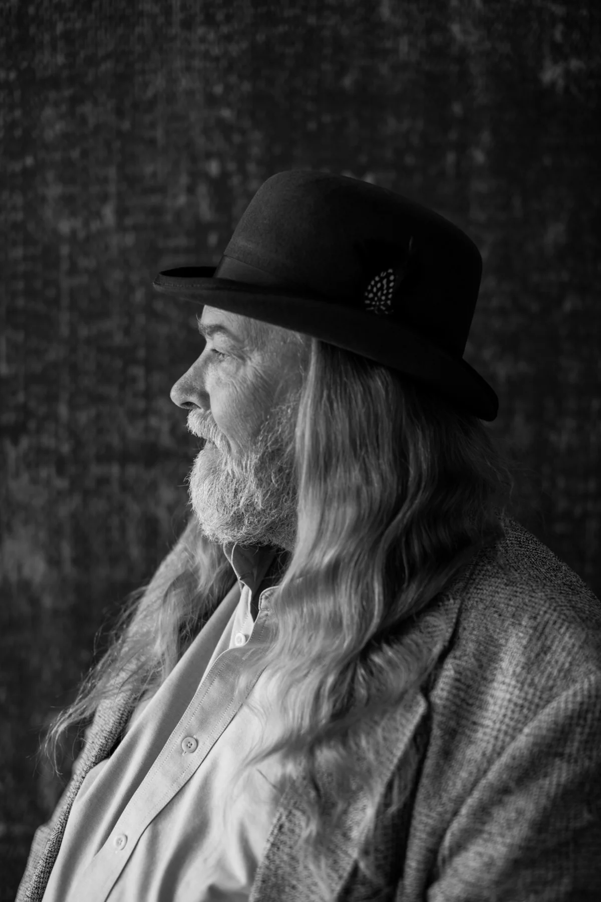 Black-and-white personal brand portrait of a man in a hat